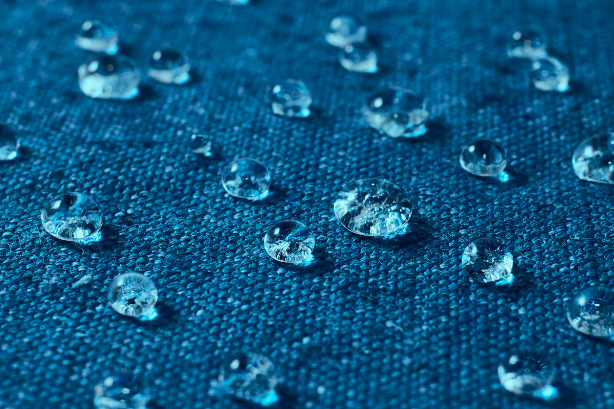 Tkanina hydrofobowa - krople wody na niebieskiej tkaninie hydrofobowej