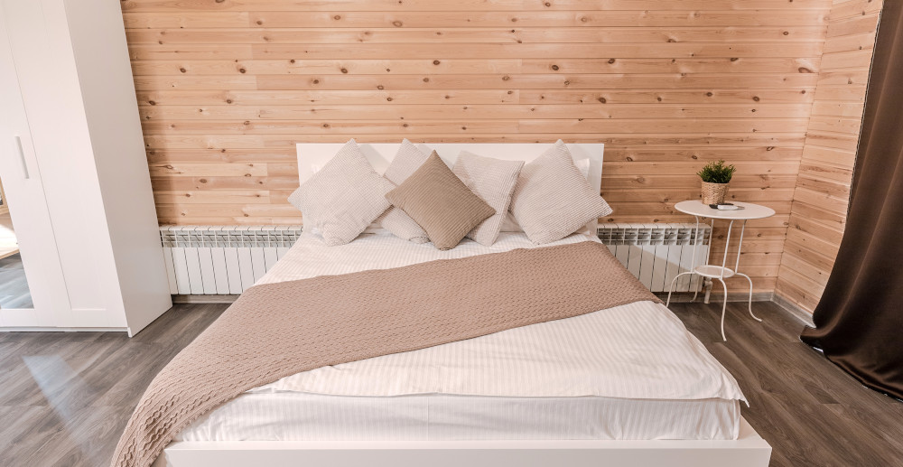 Aranżacja drewnianej ściany za łóżkiem w sypialni
